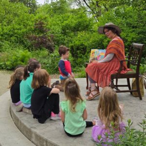 Children listening to a story outdoors in the gardens at 577.